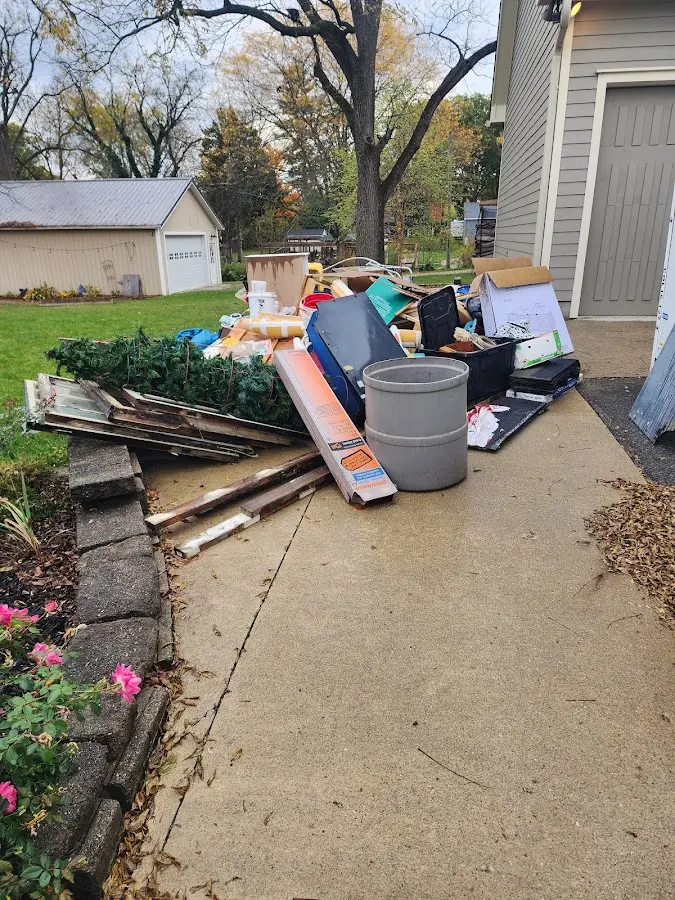 Dumpster being loaded with debris for 12 Yard Dumpster Rental in White Bear Lake